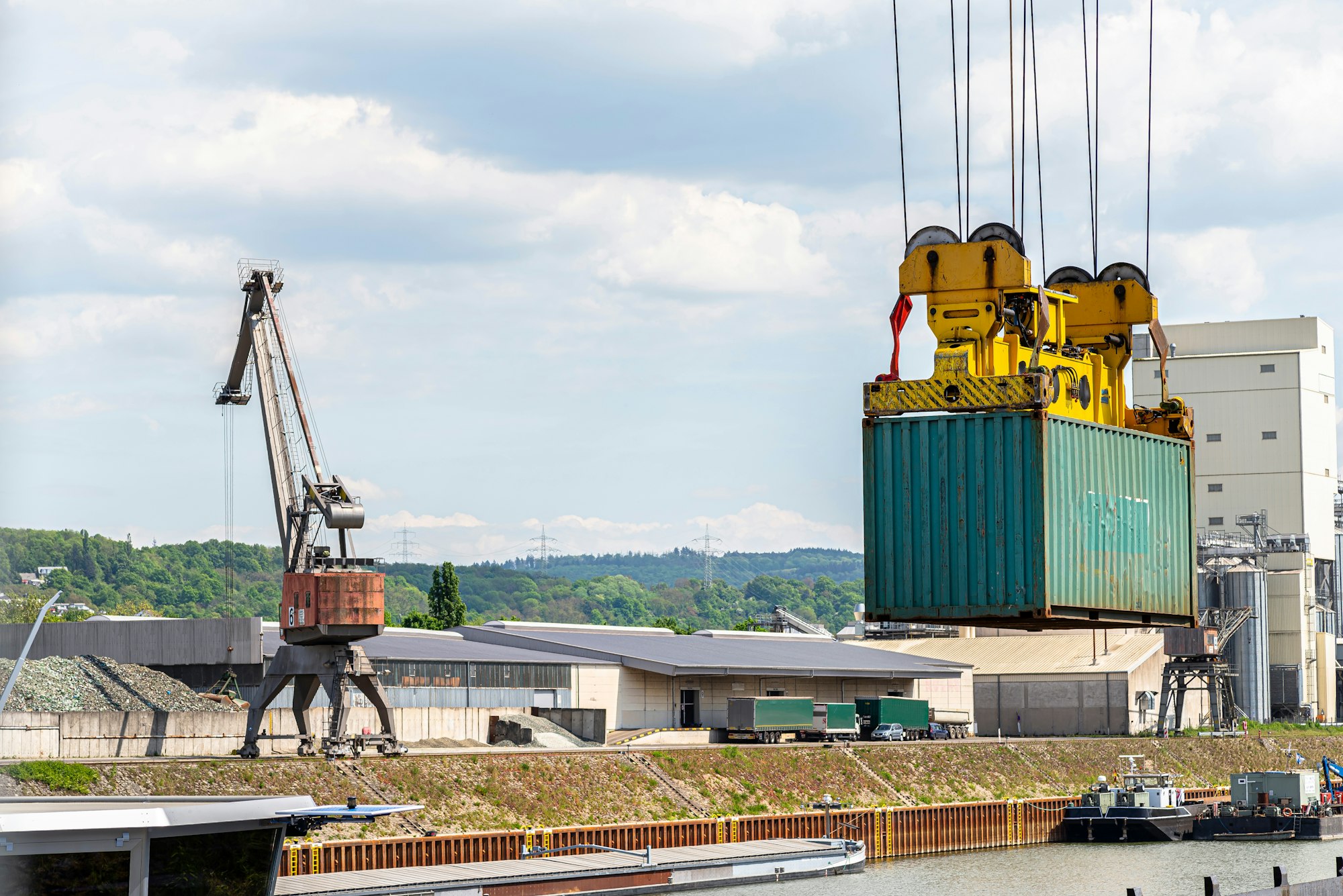 A container gantry crane on a rail loads the container into a barge